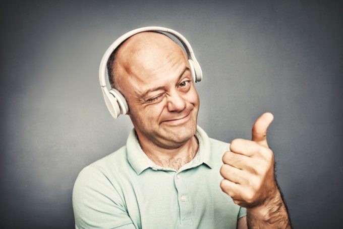 man listening to music on headphones, shows ok,